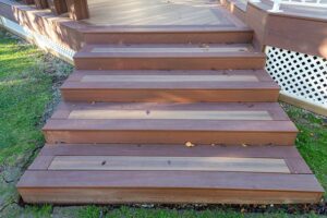 Prestige Woodworks - Christian Neudecker - Deck Builder - 2 Tiered Composite Deck, Double Boarded Fiberon Horizon Line Colour Cinnabar, Main is Fiberon Horizon Line in Colour Ike - Compass is in Fiberon Horizon Line in Colours Tudor Brown and Cinnabar - Border is face screwed and colour matched plugs - Fully Customized Railing System - 4 Custom Staircases - Customized Bench fully Clad in Matching Composite Boarded in Cinnabar to match deck with Covered matching Fascia Boards on Bases